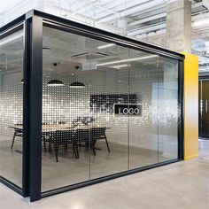 an office building with glass walls and tables in the center, surrounded by yellow partitions