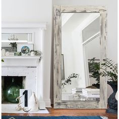 a mirror sitting on top of a wooden floor next to a fireplace