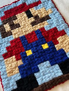 a crocheted blanket with an image of super mario on it's back