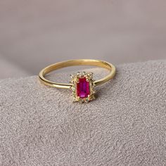 Ruby has been the best harbinger of love since time immemorial. Ruby red means fire, passion and desire itself. Along with luck, it means wealth and success.. Our rectangular ruby stone ring surrounded by real diamonds will add elegance to your hands. It is a ring that you can use both on special occasions and in daily life. It is a beautiful and stylish product that you can gift to yourself and your loved ones. The color of those born in July is the color of ruby. Our necklace compatible with o Rectangular Ruby Rings For Promise, Rectangular Ruby Promise Ring, Rectangular Ruby Ring For Gift, Rectangular Ruby Ring Gift, Ruby Halo Cluster Ring Gift, Gold Ruby Ring With Rectangular Stone For Anniversary, Red 14k Gold Cluster Ring, Ruby Ring With Halo For Gift, Ruby Ring With Halo Detail As A Gift