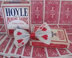 a card game with a bow tie on top of it and playing cards in the background