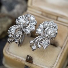 These lovely circa 1950s 14K white gold non-pierced earrings are each accented with one (1) old mine/European cut diamond set into a four-prong illusion style setting, five (5), prong set, old European cut diamonds and four (4), prong set, round single cut diamonds. The earrings measure 21mm X 12mm and are finished with 10K white gold screw style backs. Platinum Cluster Earrings With Prong Setting For Formal Events, Platinum Cluster Earrings With Prong Setting For Formal Occasions, Formal Platinum Prong Set Cluster Earrings, Classic Evening Earrings With Single Cut Diamonds, Art Deco White Gold Diamond Earrings With Brilliant Cut, Classic Cluster Earrings With Single Cut Diamonds, Classic Diamond Cluster Earrings For Anniversary, Anniversary Platinum Cluster Earrings With Brilliant Cut, Formal Single Cut Diamond Cluster Earrings