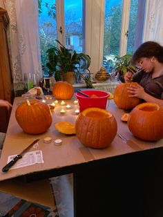 two girls are carving pumpkins on a table