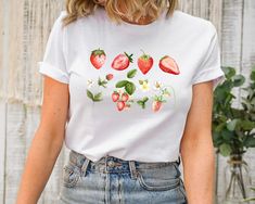 Strawberry Shirt, Botanical Shirt, Fruit Shirt, Aesthetic Clothing, Garden Shirt, Strawberry Tshirt, Strawberry Top Garden Shirt, Womens Tee Welcome to AuroraConceptDesign! ❤️ 👉🏻 PROCESSING TIME: - 3-5 business days. - Please contact with us if there is a rush order. 👉🏻 DELIVERY TIME: - Standard Shipping:  3-5 business days - Expedited Shipping  1-3 business days 👉🏻 CARE INSTRUCTIONS: - Machine wash cold and tumble dry low.  - Do not iron directly onto the design. - Do not bleach. We offer Casual Shirt With Plant Print, White Botanical Shirt For Summer, White Summer Shirt With Fruit Print, White Fruit Print Shirt For Summer, Summer White Shirt With Fruit Print, Casual Strawberry Print Shirt For Spring, Botanical Style Shirt With Relaxed Fit For Summer, Botanical Style Relaxed Fit Shirt For Summer, White Strawberry Print Shirt For Spring