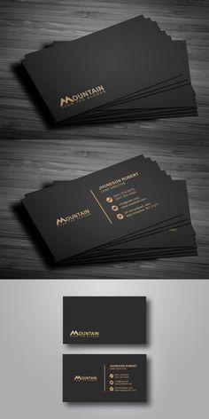 some black and gold business cards on top of a wooden table, with the words mountain written