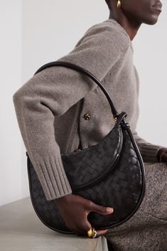 Bottega Veneta's Gemelli bag is defined by its crescent-shaped pouch that adds dimension to the curved design. It's crafted using the intrecciato weave first developed by the brand in the '60s to enhance the durability of leather. Thread your wrist through the top to carry it as a clutch. Elegant Everyday Shoulder Bag With Woven Leather, Elegant Baguette Bag Pouch For Office, Elegant Pouch-shaped Baguette Bag For Office, Elegant Bags With Woven Leather And Round Handle, Elegant Bag With Woven Leather And Round Handle, Luxury Structured Hobo Bag, Elegant Shoulder Bag With Woven Leather And Round Handle, Luxury Structured Hobo Bag For Formal Occasions, Elegant Formal Baguette Bag With Leather Handles