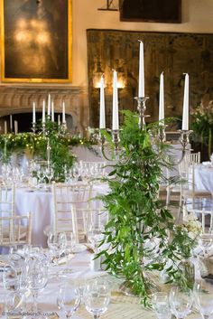 the table is set with candles and greenery