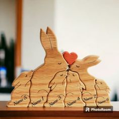 two wooden rabbits kissing each other with their names on the front and back, as if they were carved from wood