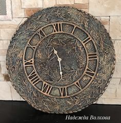 an ornate clock with roman numerals on the face is displayed in front of a brick wall