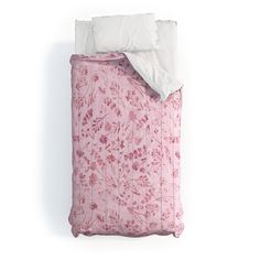 a pink floral comforter with white pillows