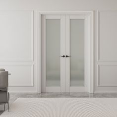 an empty white room with two chairs and a glass door that leads to another room