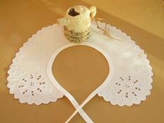 a white lace doily on top of a table next to a vase and spoon