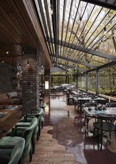 an outdoor dining area with tables and chairs under a pergolated roof that overlooks the forest