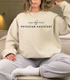 "Look professional and stylish in our Physician Assistant Sweatshirt! This comfortable, long-sleeved pullover is designed with a modern fit and features the modern Physician Assistant style on the front. Perfect for studying or casual wear, this classic sweatshirt is sure to become a favorite. Crafted from a lightweight cotton blend fabric, it's breathable and durable, so you can wear it all year round. Show your support for the profession and stay comfortable while doing it! In PA school or gra Physician Associate, Physician Assistant School, Pa School, Physician Assistant, New Career, Logo Color, Baggy Fits, Sew-in Labels, Modern Fit