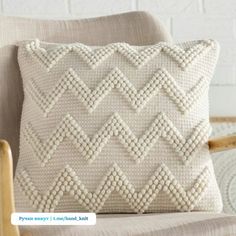 a white pillow sitting on top of a chair