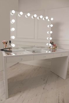 a vanity table with lights on it in a room