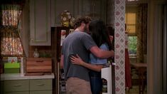 the young couple is hugging in the kitchen