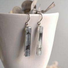 Arrow earrings in gray and black colors in handmade glass. Unique sustainable gift for men or women. Total drop length: 1 21/32 inches (42 millimeters) Ear hooks of solid sterling silver ideal for sensitive skin. They're not heavy, and comfortable to wear on a daily basis. You'll receive your earrings nicely packaged ready to give as gift. Recycled window glass deriving from buildings in the beautiful city of Barcelona. Discarded windows come back to life as unique pieces of jewelry. Thank you f Gray Dangle Jewelry For Gifts, Minimalist Glass Earrings For Gift, Gray Ear Wire Earrings For Gift, Gray Drop Earrings For Gift, Arrow Earrings, Fused Glass Jewelry, Unisex Gift, Eco Friendly Jewelry, Window Glass