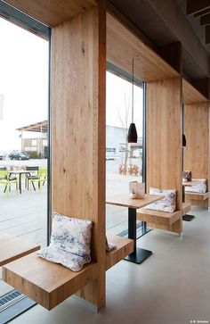 a restaurant with wooden benches and windows