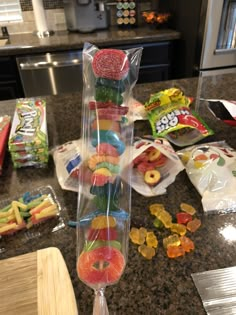 a bunch of gummy bears sitting on top of a counter next to some fruit