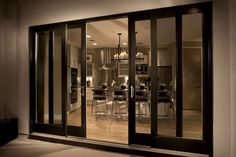 an open glass door leading into a dining room