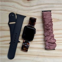 an apple watch and other accessories laid out on a wooden surface with the strap pulled back