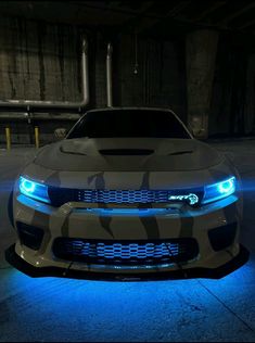 the front end of a white camo car with blue lights on it in a parking lot