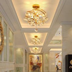 an elegant hallway with chandeliers and paintings on the walls, along with marble flooring