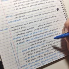 a person is writing on a notebook with a blue pen in their left hand and the page has been written out