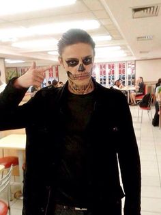 a man in black shirt and skeleton makeup pointing at the camera