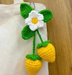 two crocheted strawberries hanging from a string