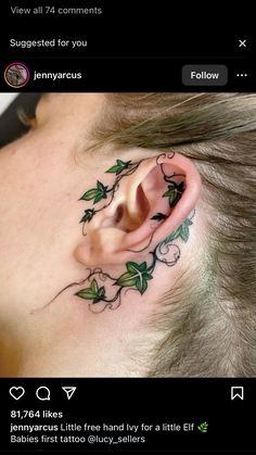 an ear tattoo with green leaves on it