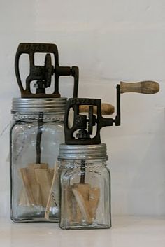 two mason jars filled with wooden spoons on top of a white counter next to each other