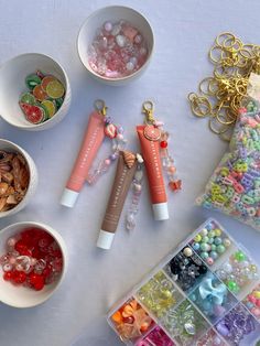 several small bowls filled with candy, beads and other items on top of a table