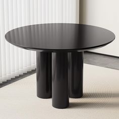 a black table sitting on top of a carpeted floor next to a white wall