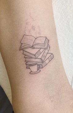 a tattoo on the leg of a woman with books