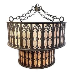 a hanging light fixture with an intricate design on the front and back sides, made out of metal