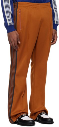 Polyester interlock jersey track pants. · Concealed drawstring at elasticized waistband · Three-pocket styling · Logo embroidered at front · Pinched seams at front · Striped knit trim at outseams Supplier color: A-rust Striped Knit, Logo Embroidered, Track Pants, Rust, Track, Trim, Orange, ? Logo, Knitting