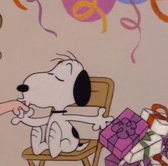 a cartoon dog sitting in a chair with balloons and presents on the floor next to him