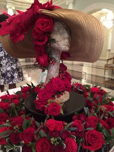 a hat on top of a table with red roses