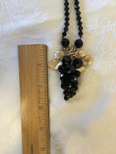 "This striking vintage black necklace features an attached grape cluster pendant. The jet black beads are faceted glass and the 1950's/60's necklace is in superb condition, with the grape leaves and stem accented in gold tone. Excellent for vintage looks or mix old and new for fun. Measures approximately: Pendant 2 1/2\" X 2\" X necklace length is 33\" As always, local pickup is available and preferred so that you may see all of our other wonderful items. Aphrodite's Antiques & Gifts 11 Milt Vintage Black Bead Necklaces For Evening, Vintage Black Beaded Necklace For Evening, Vintage Black Beads Necklace For Evening, Vintage Black Beaded Party Necklace, Vintage Black Beaded Necklace For Party, Vintage Black Beaded Necklaces For Party, Mid Century Classic, Enamel Locket, Rhinestone Jewelry Set