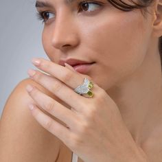 This ring from German Kabirski's Buds and Beans Collection challenges conventional design with its unique setting of two octagon-cut Peridot gemstones. One stone is set vertically, the other horizontally, embodying a design perfect for those who appreciate seeing things from multiple perspectives and find harmony in contrasts. The dual plating of White Rhodium and 18K Gold enhances the design's complexity, while the band's organic-like texture—a signature of Kabirski's work—adds an earthy, tacti Luxury Multi-stone Peridot Ring, Luxury Peridot Multi-stone Rings, Luxury Peridot Rings With Accent Stones, Emerald Cut Peridot Gemstone Jewelry, Luxury Multi-stone Peridot Jewelry, Luxury Peridot Multi-stone Jewelry, Fusion Style Peridot Gemstone Jewelry, Elegant Peridot Ring Jewelry, Octagon Diamond Ring With Gemstone Accents