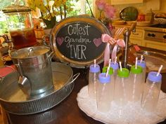 there are many cups with toothbrushes in them on the table next to a chalkboard