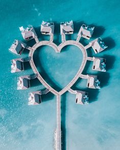 an aerial view of a heart - shaped structure in the water with several buildings on it