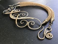 The centerpiece for this unique necklace was created by weaving swirls of silver wire together using both Argentium sterling silver and 14 kt. gold-fill wire. The side chains are handwoven 14 kt. gold-fill, using the "Viking knitting" technique. Every version of this necklace is absolutely unique. Elegant Handwoven Silver Jewelry, Elegant Spiral Wire Wrapped Jewelry, Elegant Spiral Filigree Jewelry, Gold Multi-strand Wire Wrapped Jewelry, Gold Wire Wrapped Multi-strand Jewelry, Artisan Handwoven Silver Jewelry, Elegant Spiral Necklaces For Jewelry Making, Unique Gold Spiral Necklace, Elegant Spiral Jewelry With Unique Design