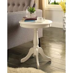 a white table sitting in front of a window on top of a hard wood floor