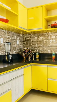 a kitchen with yellow cabinets and black counter tops