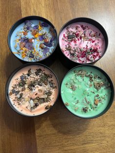 four bowls filled with different types of food on top of a wooden table next to each other