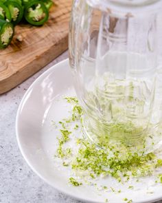 a white plate topped with food next to a cutting board and green pepper shaker