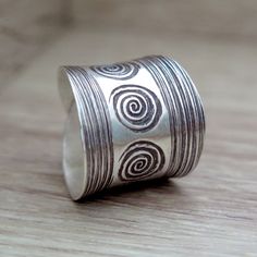 "Handmade Sterling Silver Wide Band Adjustable Wrap Ring with Tribal Ethnic style Engraved Oxidised Spirals swirls, Can be used also as Thumb Ring,for women or men Width (front aspect): 0.8\" / 2cm Metal Purity: 95% Silver (Purer than 925 Sterling Silver) To browse some more of our silver jewelry collection you can click on the following links: https://www.etsy.com/shop/SilverShapes Earrings: https://www.etsy.com/shop/SilverShapes?section_id=14809462&ref=shopsection_leftnav_1 Rings: https:// Mens Ring Designs, Wide Band Ring, Thumb Ring, Wide Band Rings, Mens Ring, Thumb Rings, Wrap Rings, Handmade Boho, Wide Bands